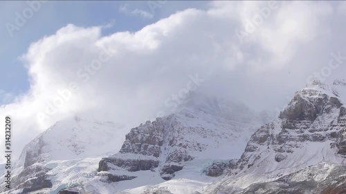 Clouds Cruising By Snow Capped Peaks of The Rocky Mountains -  wide shot photo