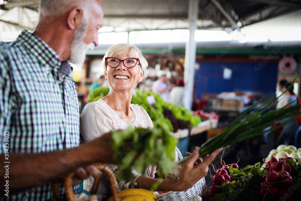 Only the best fruits and vegetables. Beautiful mature couple buying fresh food on market Only the best fruits and vegetables. Beautiful mature couple buying fresh food on market