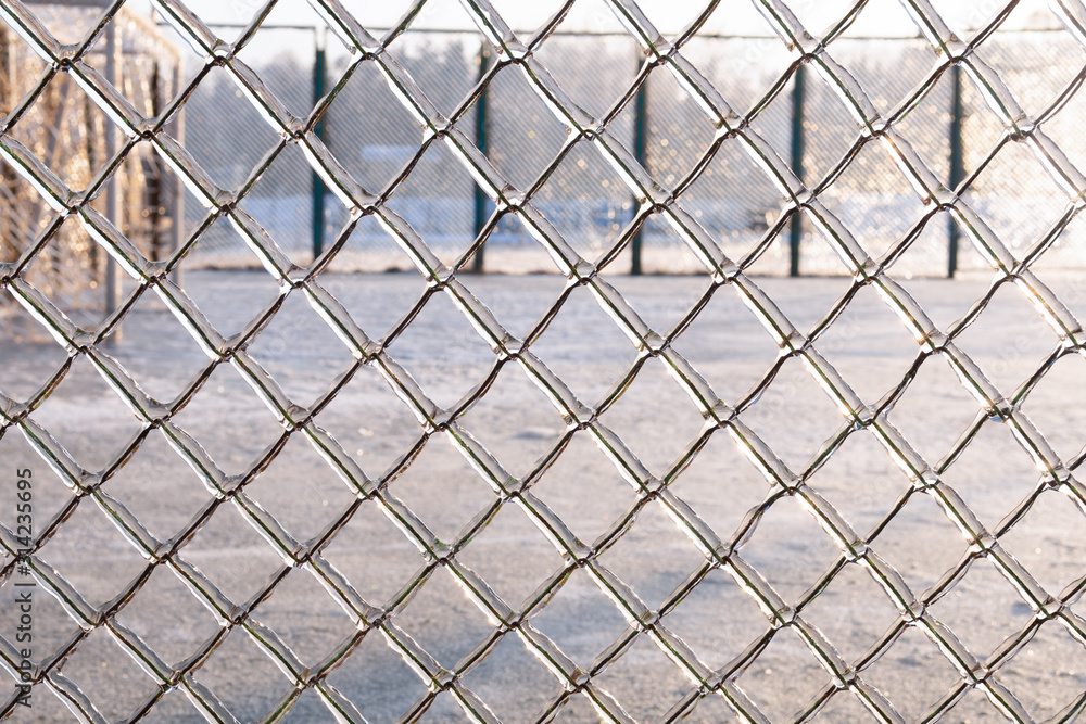 Fototapeta premium The fence is covered with ice after freezing rain