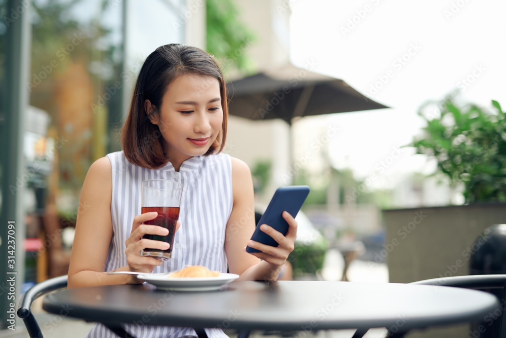 Portrait of beautiful young woman using smartphone while enjoying evening on outdoor coffee shop, copy space Portrait of beautiful young woman using smartphone while enjoying evening on outdoor coffee shop, copy space