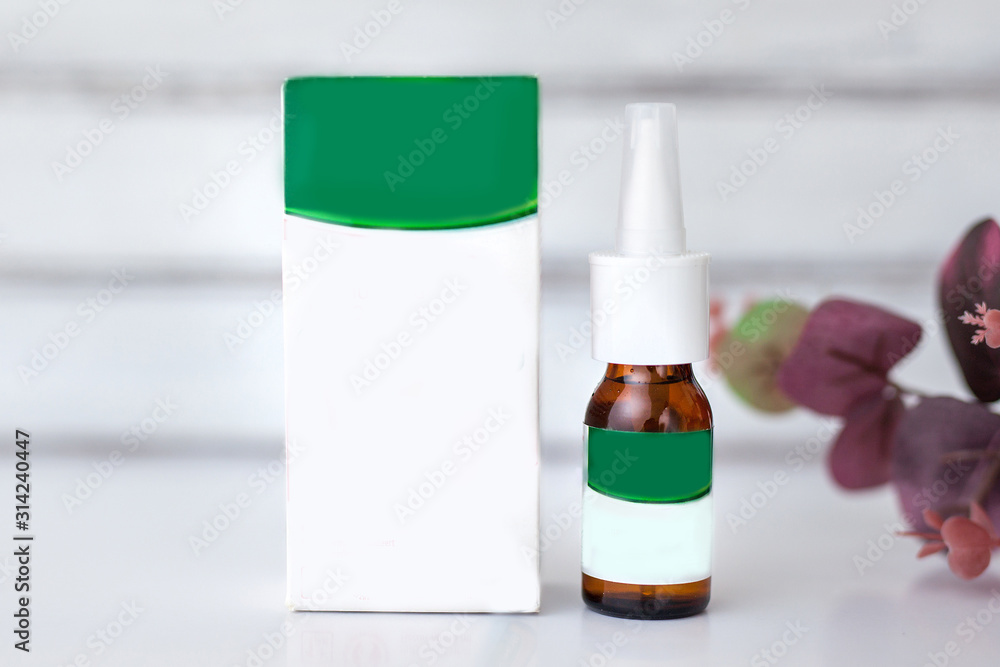 spray for a nose with a box of light white lie on a white table spray for a nose with a box of light white lie on a white table