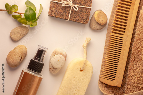 Spa wellness concept flatlay, natural coffee scrub soap, oil cosmetic spray, peeling sand stone, towel, natural wooden haircomb.Beige brown dayspa set copyspace.Pastel bathroom accessories and product