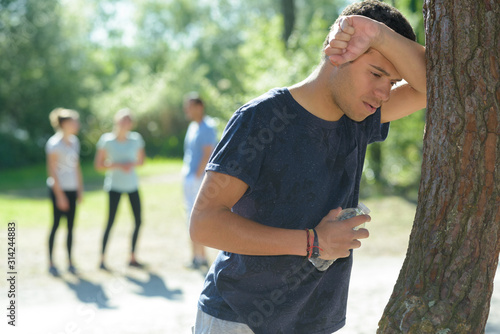 young man feeling sick doing outdoor exercise photo