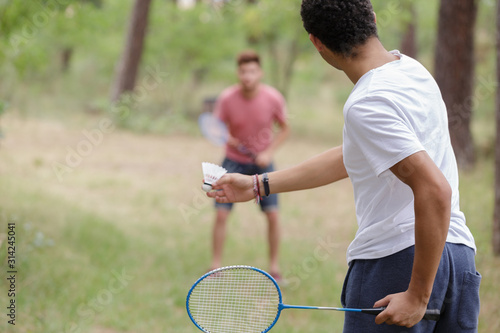 two men playing badminton outdoors