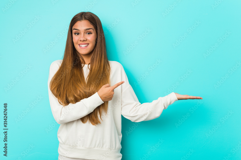 Young slim woman excited holding a copy space on palm. Young slim woman excited holding a copy space on palm.
