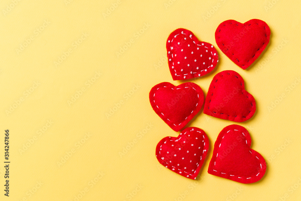 Composition of textile red hearts on colorful background with empty space for your design. Top view of St. Valentine's day concept Composition of textile red hearts on colorful background with empty space for your design. Top view of St. Valentine's day concept