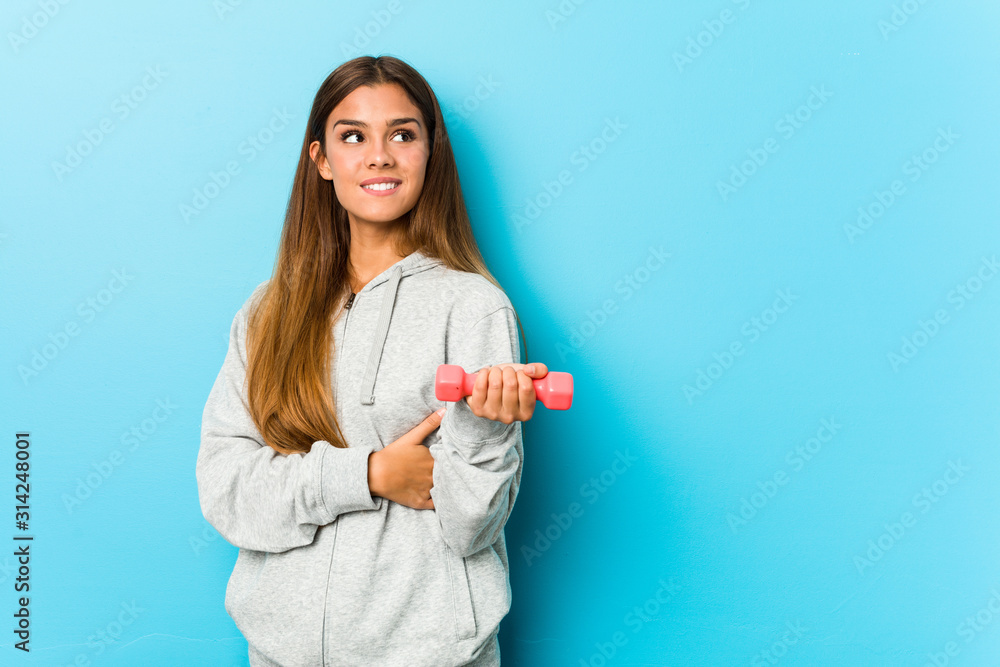 Young fitness woman holding a weight smiling confident with crossed arms. Young fitness woman holding a weight smiling confident with crossed arms.