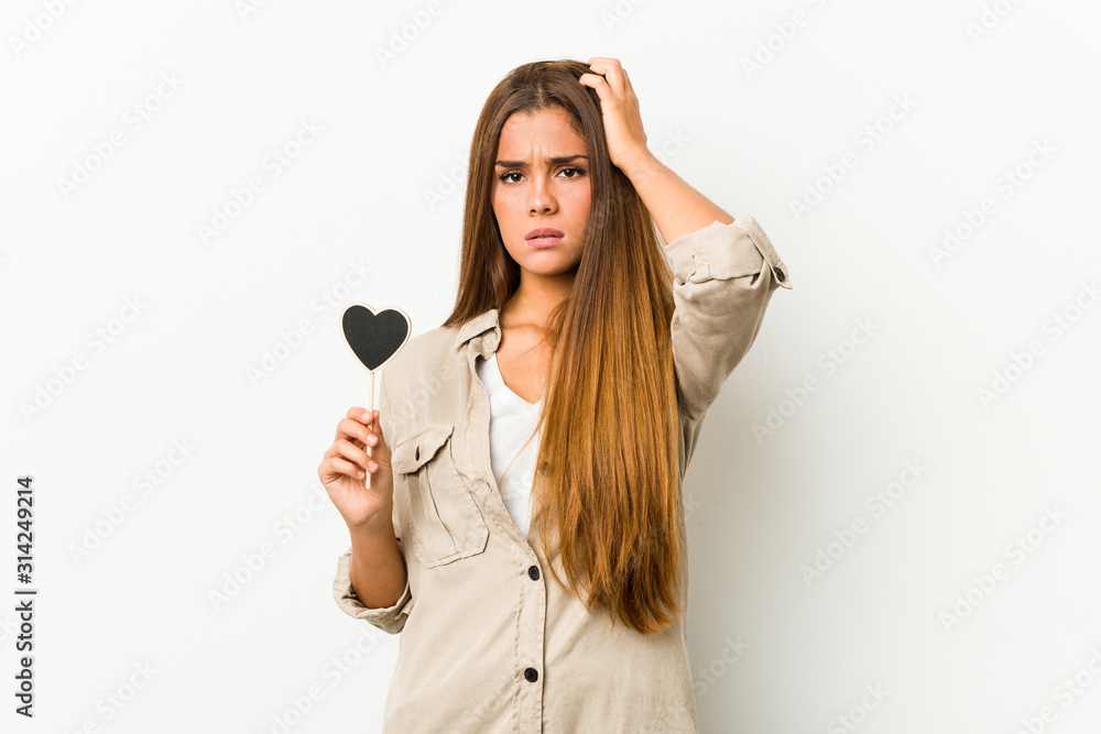 Young caucasian woman holding a heart shape being shocked, she has remembered important meeting. Young caucasian woman holding a heart shape being shocked, she has remembered important meeting.