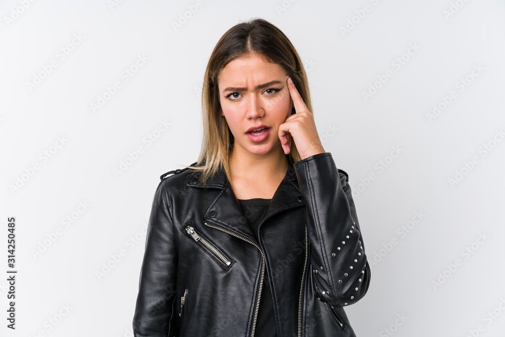 Young caucasian woman wearing a black leather jacket showing a disappointment gesture with forefinger. Young caucasian woman wearing a black leather jacket showing a disappointment gesture with forefinger.