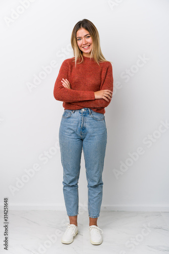 Fototapeta Full body young caucasian woman who feels confident, crossing arms with determination