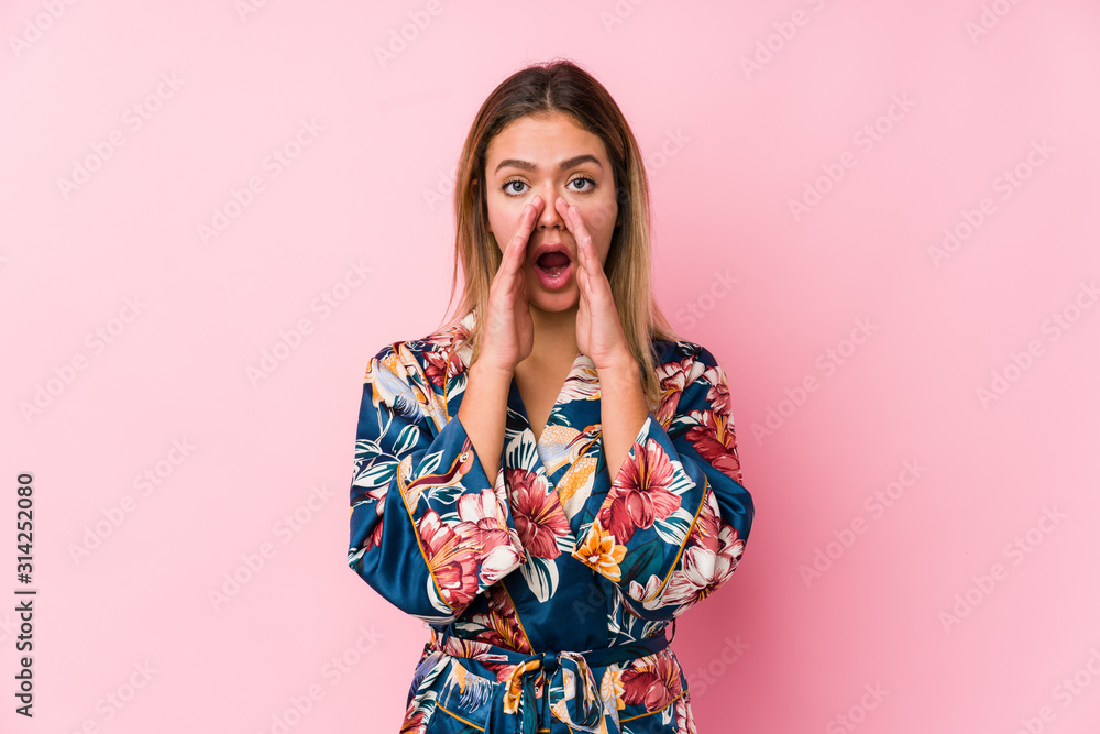 Young caucasian woman wearing pajamas shouting excited to front. Young caucasian woman wearing pajamas shouting excited to front.