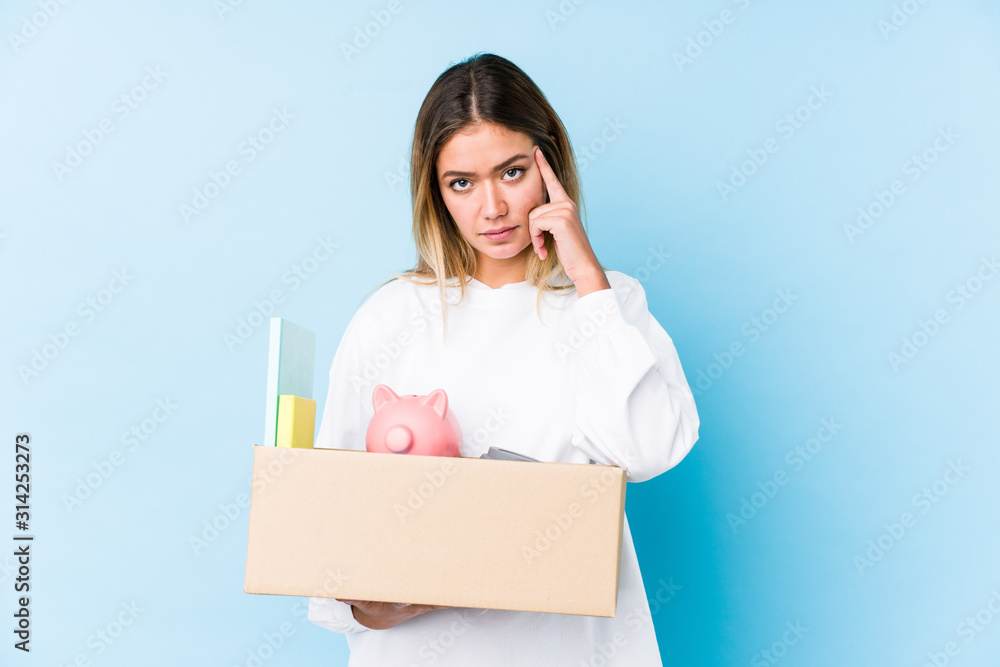 Young caucasian woman moving home isolated pointing his temple with finger, thinking, focused on a task. Young caucasian woman moving home isolated pointing his temple with finger, thinking, focused on a task.