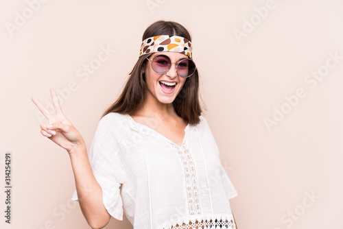 Young hipter caucasian woman isolated joyful and carefree showing a peace symbol with fingers.