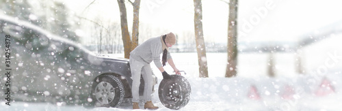 A man near a broken car on a winter day