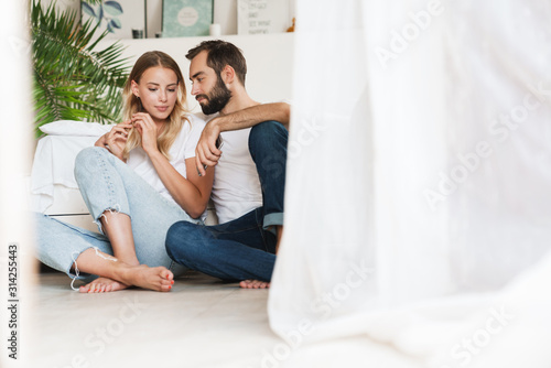 Cheerful beautiful young couple sitting at the couch