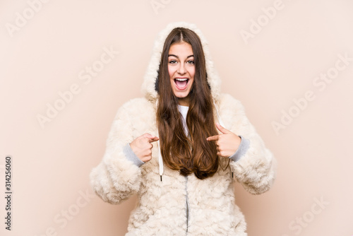 Young caucasian woman posing isolated surprised pointing with finger, smiling broadly.