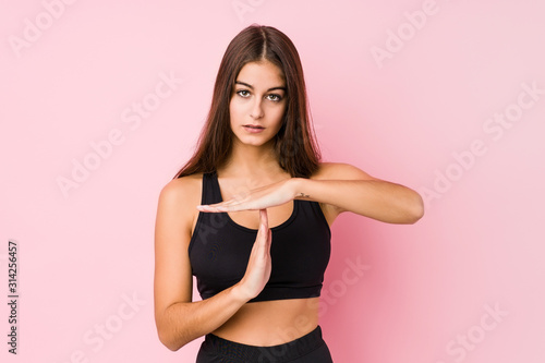 Young caucasian fitness woman doing sport isolated showing a timeout gesture.