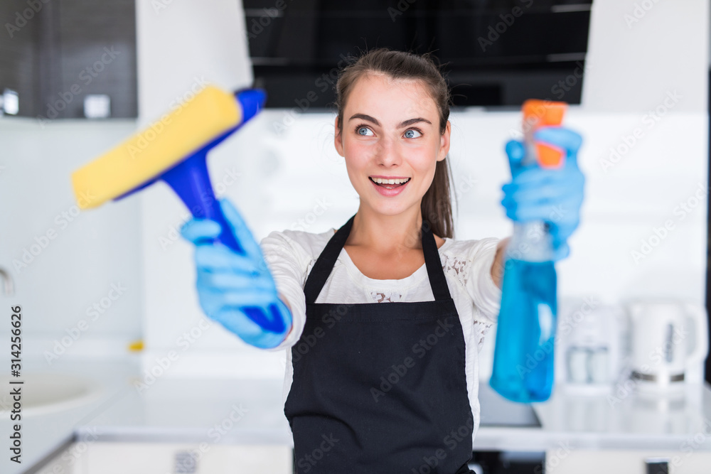 Young pretty woman hoding clean tools standing in the kitchen Young pretty woman hoding clean tools standing in the kitchen