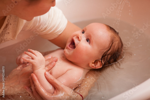 Cute baby bathes, laughs and smiles. The concept of a toddlers ' swimming.