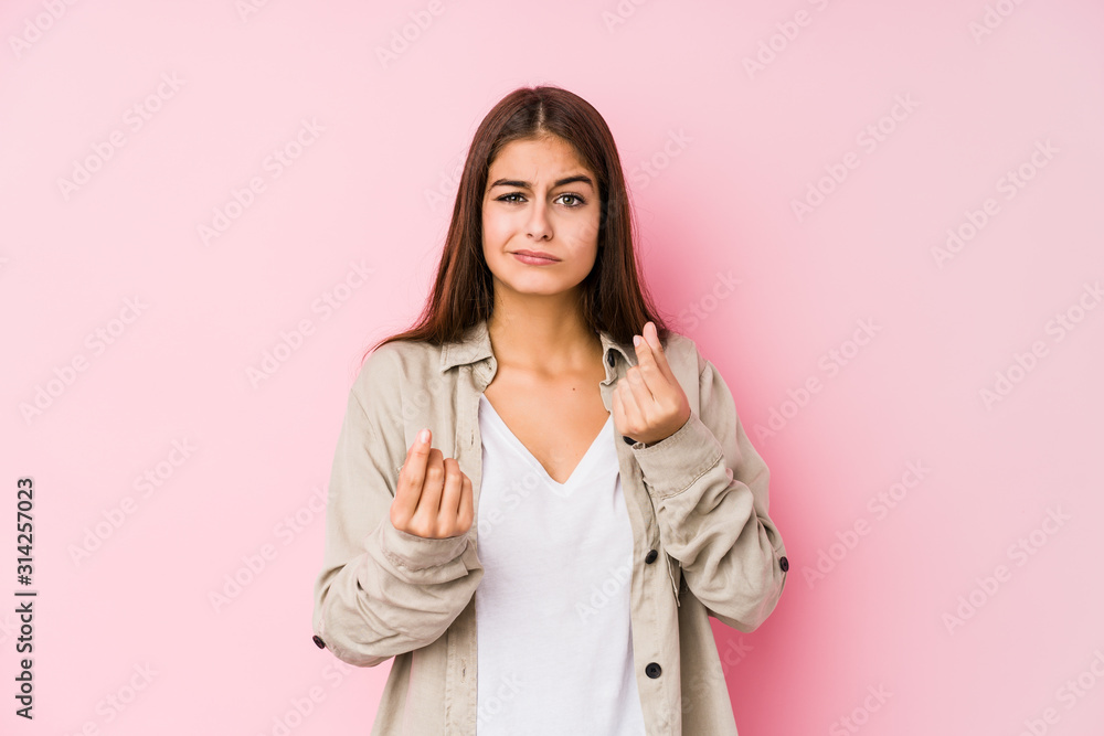Young caucasian woman posing in a pink background showing that she has no money. Young caucasian woman posing in a pink background showing that she has no money.