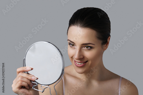 Girl looking in mirror enjoying her makeup