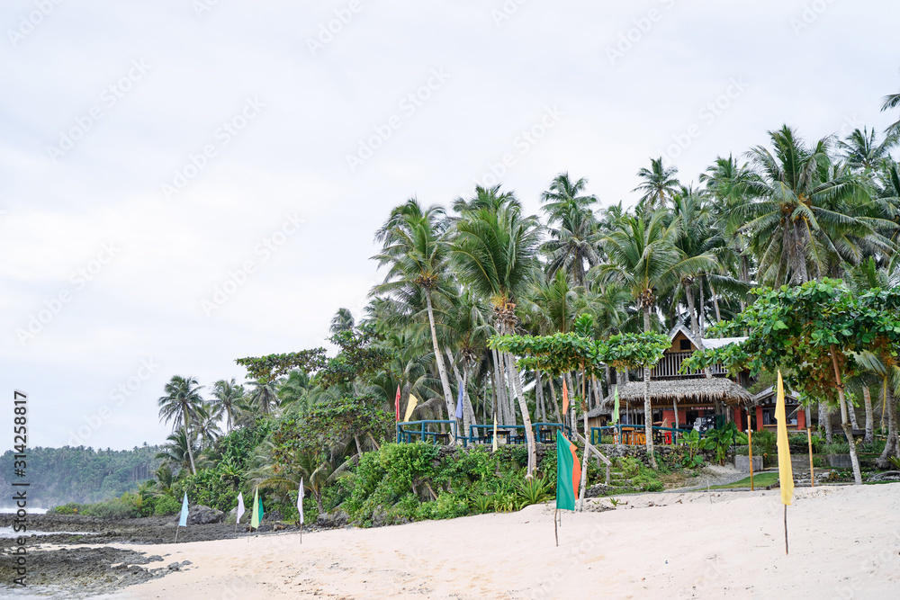 Beautiful landscape. White sand beach with colorful flags on it. Siargao Island, Philippines. Beautiful landscape. White sand beach with colorful flags on it. Siargao Island, Philippines.