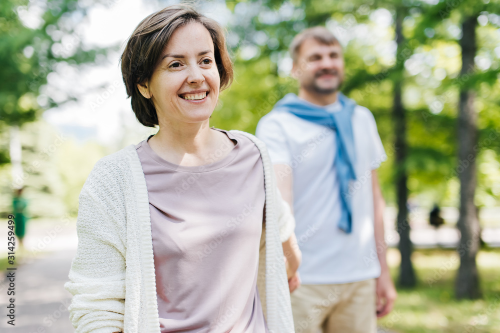 Middle-aged married couple walking in the park. Middle-aged married couple walking in the park.