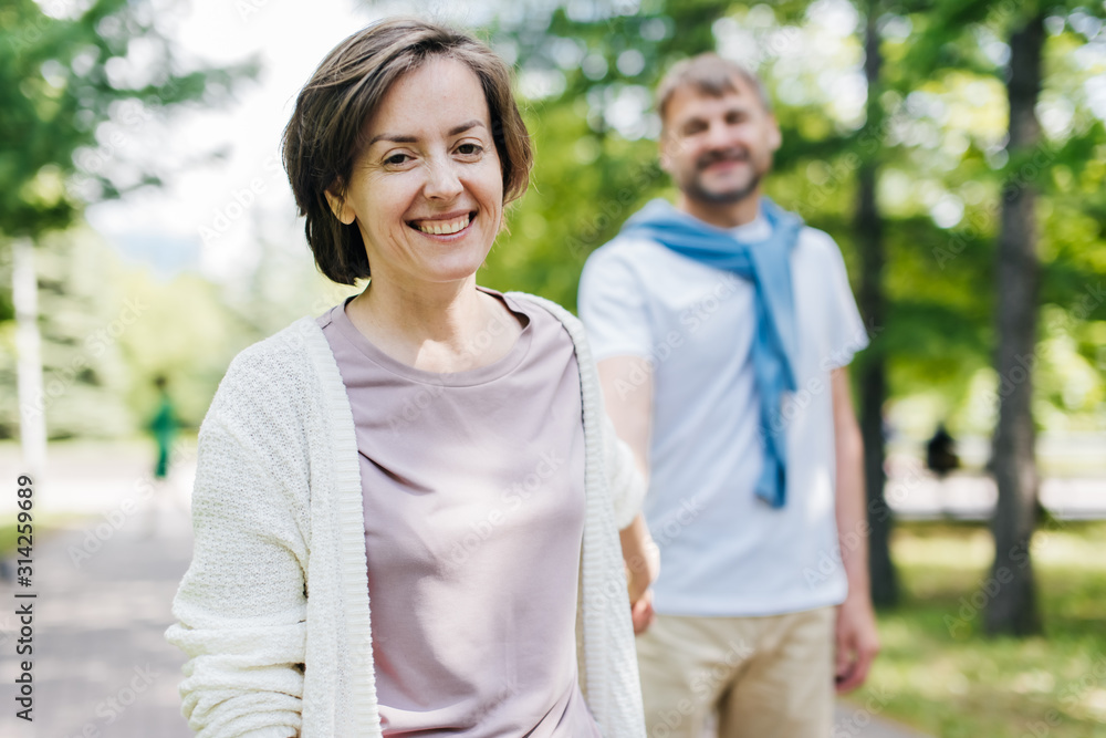 Portrait of a woman smiling while holding her husband's arm. Portrait of a woman smiling while holding her husband's arm.