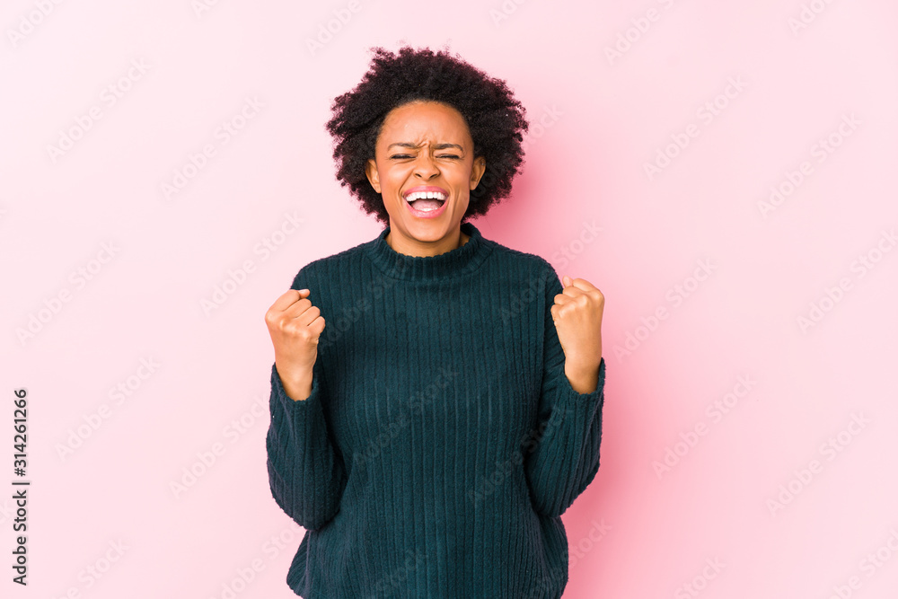 Middle aged african american woman against a pink background isolated cheering carefree and excited. Victory concept. Middle aged african american woman against a pink background isolated cheering carefree and excited. Victory concept.
