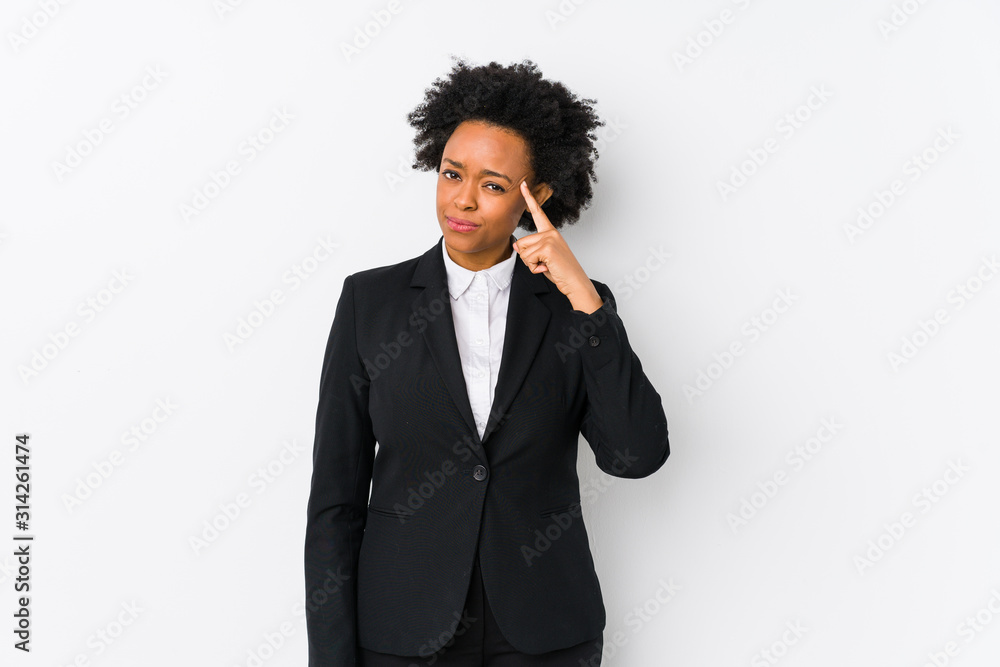 Middle aged african american business woman against a white background isolated pointing temple with finger, thinking, focused on a task. Middle aged african american business woman against a white background isolated pointing temple with finger, thinking, focused on a task.