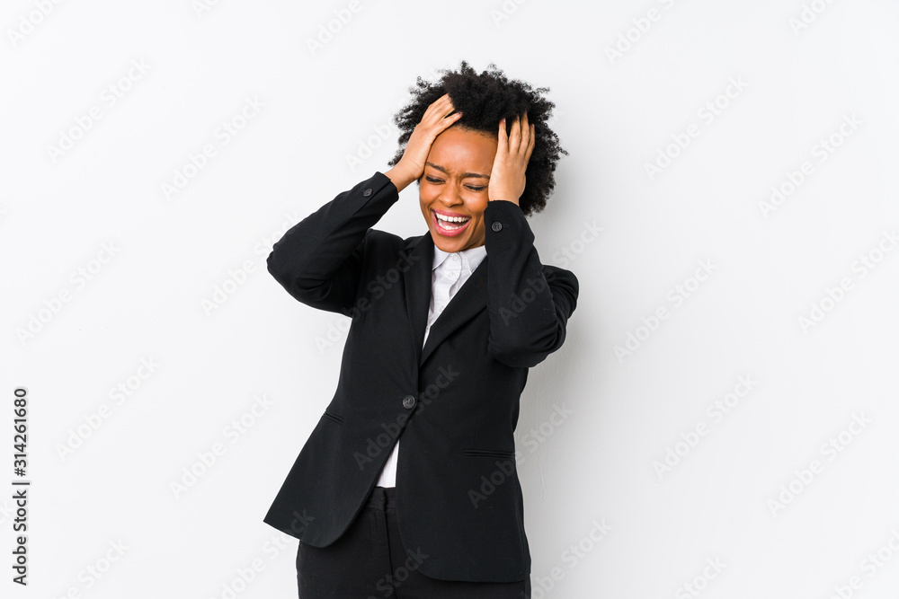 Middle aged african american business woman against a white background isolated laughs joyfully keeping hands on head. Happiness concept. Middle aged african american business woman against a white background isolated laughs joyfully keeping hands on head. Happiness concept.