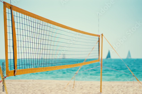 Yellow volleyball net on sea beach.