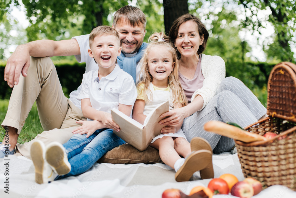 Portrait of a happy family at the picnic with a book. Portrait of a happy family at the picnic with a book.