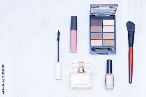 Set of cosmetics for make up (brushes, shadows). Make up nude essentials on white wooden background. Flat lay, copy space, blogging concept.