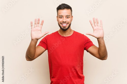 Young south-asian man showing number ten with hands. © Asier