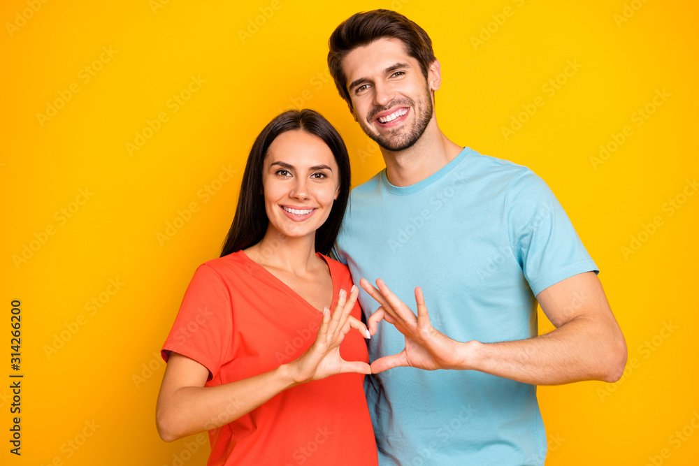 Photo of amazing two people guy lady celebrating valentine day holding fingers heart figure shape wear casual blue orange t-shirts isolated yellow color background - obrazy, fototapety, plakaty 