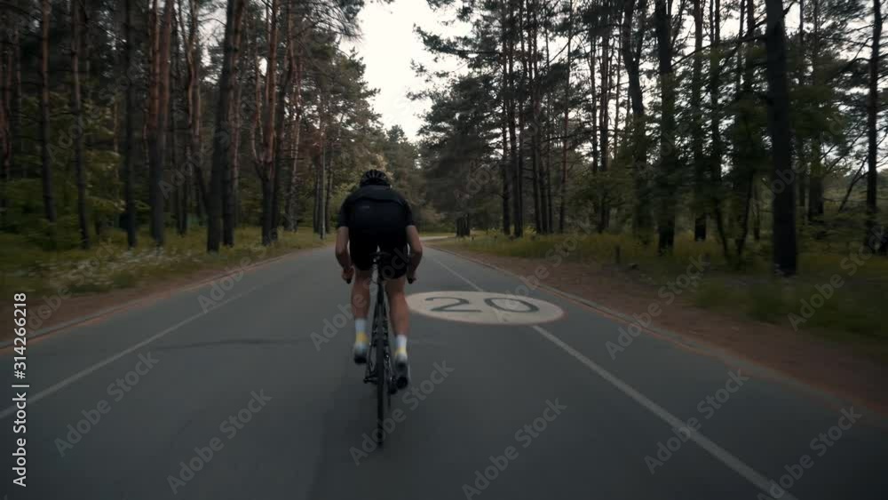 Cyclist Cycling In Helmet On Bicycle.Cycling On Sunset Time Or Dusk.Triathlete Training For For Ironman Race At Evening.Cyclist Professional Fit Man On Triathlon Bicycle. Cyclist Cycling In Helmet On Bicycle.Cycling On Sunset Time Or Dusk.Triathlete Training For For Ironman Race At Evening.Cyclist Professional Fit Man On Triathlon Bicycle.