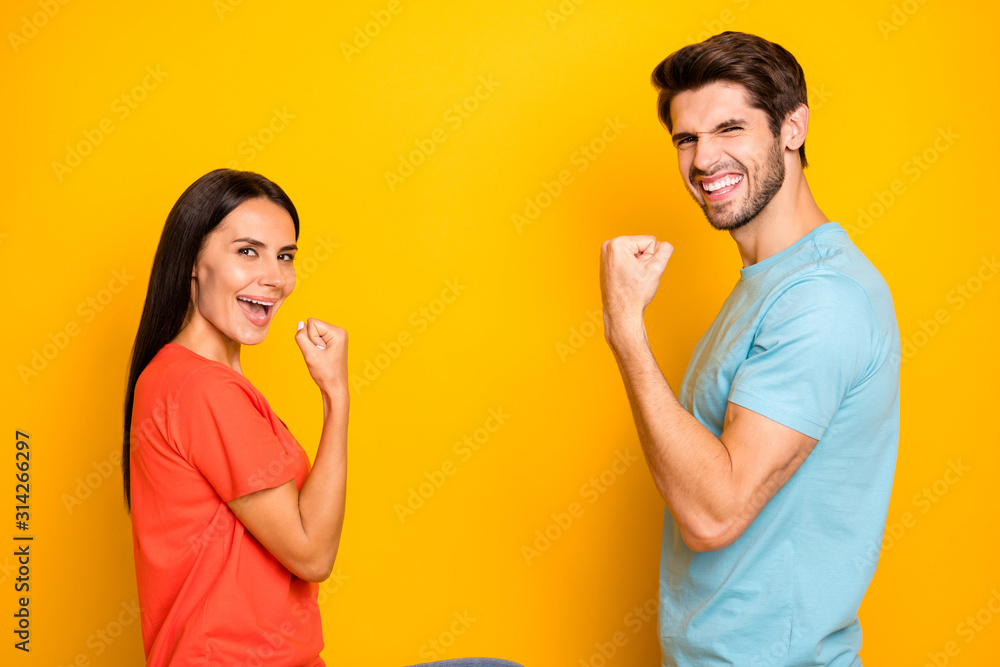Profile photo of funny two people guy lady celebrating competition winning sportive champions wear casual blue orange t-shirts jeans isolated yellow color background Profile photo of funny two people guy lady celebrating competition winning sportive champions wear casual blue orange t-shirts jeans isolated yellow color background