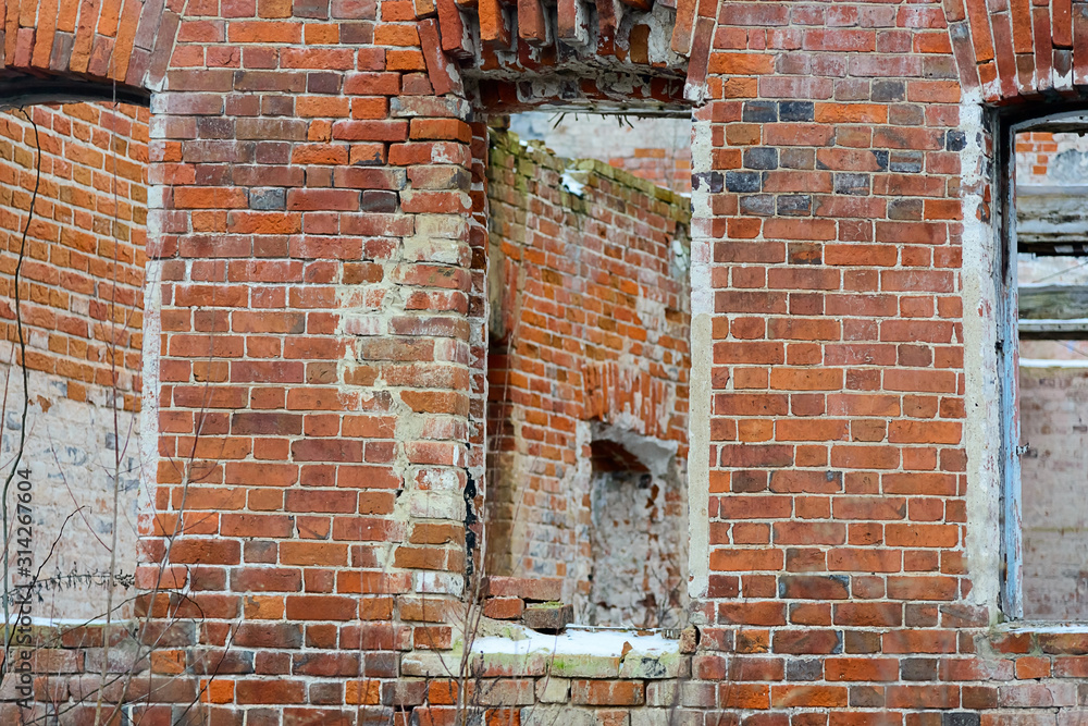 Fragment of a destroyed brick wall with empty windows