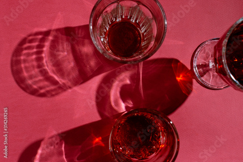 Flatlay of various glasses of wine on pink background, selective focus