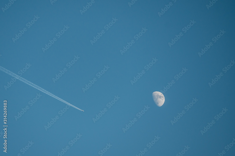 airplane and moon in blue sky