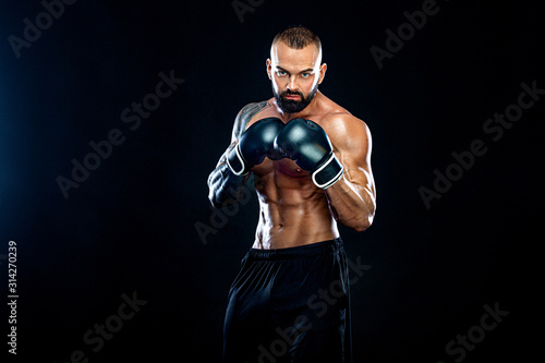 Fitness and boxing concept. Boxer  man fighting or posing in gloves on black background. Individual sports recreation.