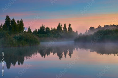 Misty morning on a small lake. Atmospheric sunrise. © Rolandas