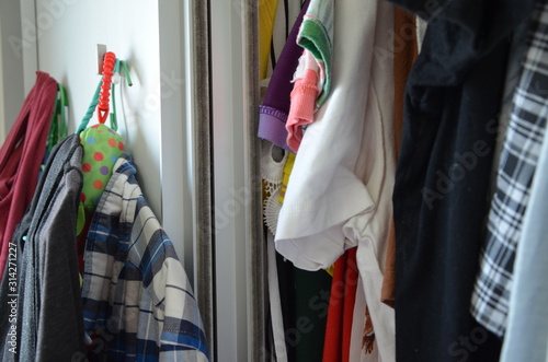 Wardrobe full of cloth. Unorganized home. Fast fashion over consumption.