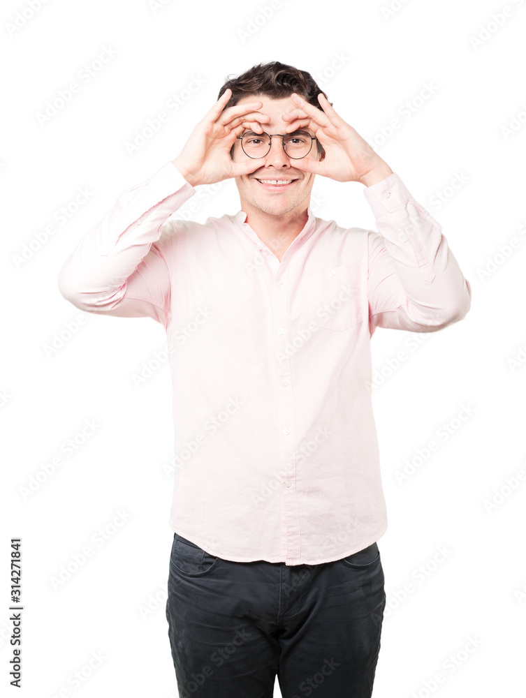 Happy young man using his hands like a binoculars Happy young man using his hands like a binoculars