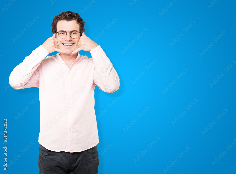 Happy young man making a gesture of calling with the hand Happy young man making a gesture of calling with the hand
