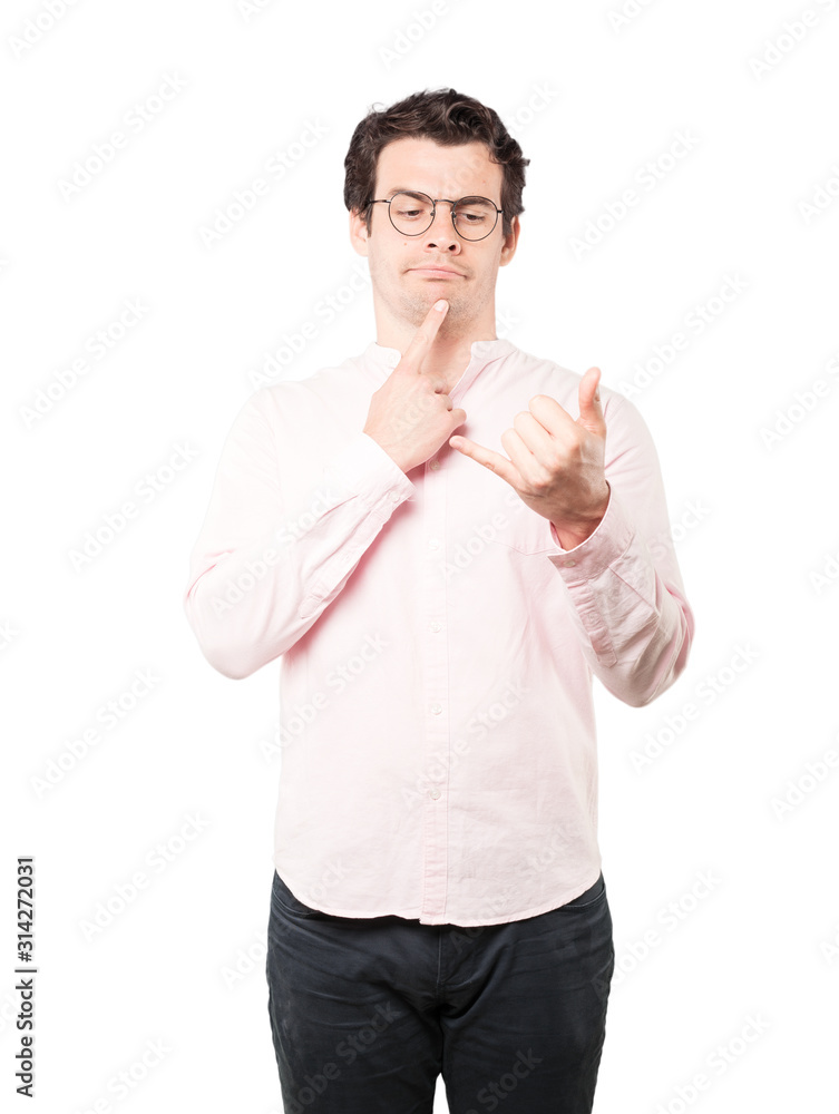 Hesitant young man making a gesture of calling with the hand