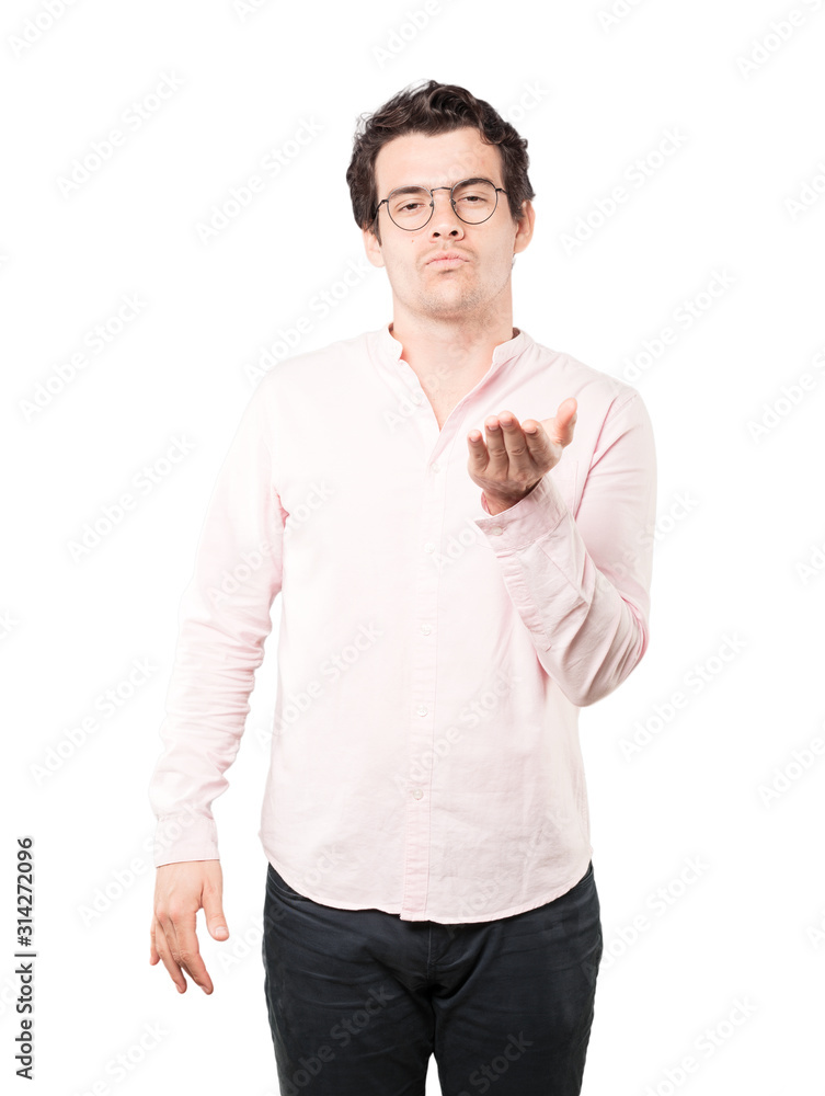 Friendly young man making a gesture of sending a kiss with his hand Friendly young man making a gesture of sending a kiss with his hand