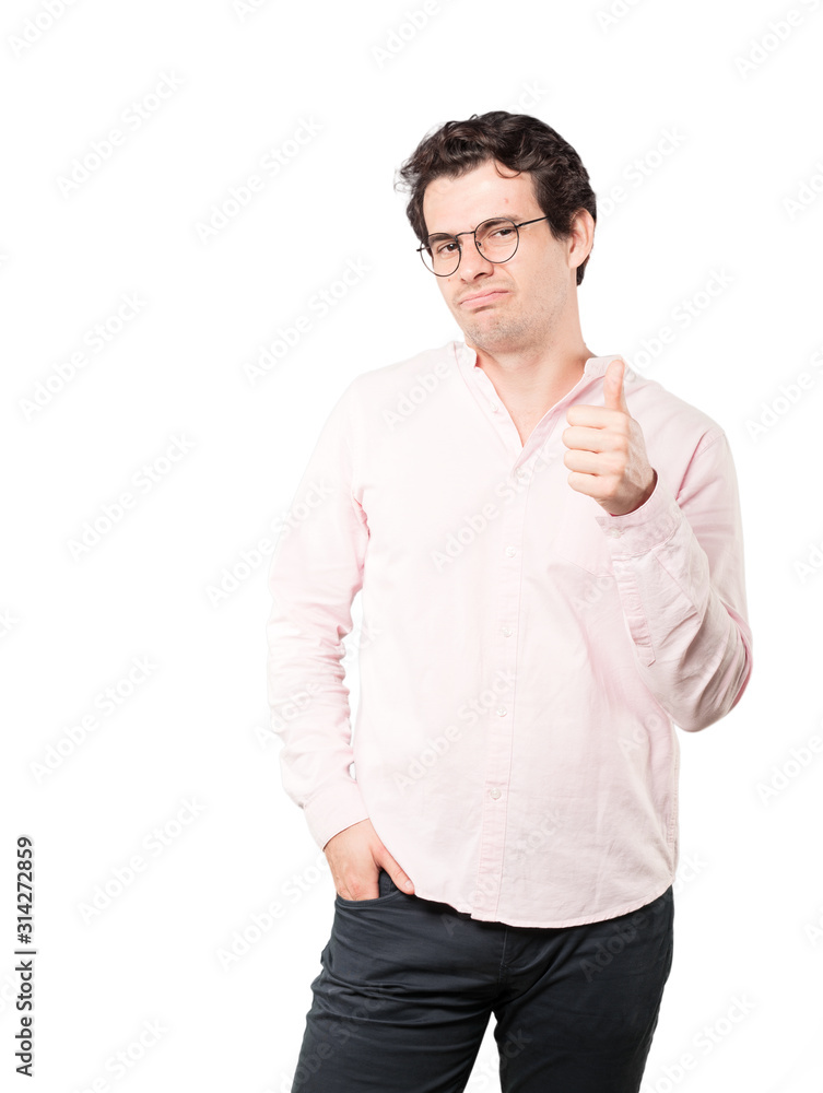 Hesitant young man gesturing that everything is fine Hesitant young man gesturing that everything is fine