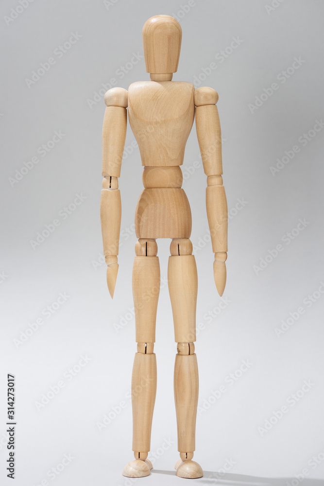 Wooden doll with hinges on grey background